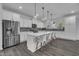 Modern kitchen with a large kitchen island, stainless steel appliances, white cabinets and grey backsplash at 1410 Arena Ln, Fuquay Varina, NC 27526