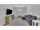 Comfortable living room featuring gray sofa, tv, stylish furniture, and neutral carpeting at 1410 Arena Ln, Fuquay Varina, NC 27526