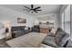 Living room with grey couches, ceiling fan, open concept design and view of a modern kitchen at 1410 Arena Ln, Fuquay Varina, NC 27526
