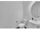 Clean and modern powder room with pedestal sink, white toilet and contemporary fixtures at 1410 Arena Ln, Fuquay Varina, NC 27526