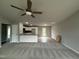 Open-concept living area with gray walls, plush carpeting, and a kitchen with modern appliances at 146 Starry Sky Dr, Benson, NC 27504