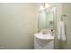 Cozy half-bathroom featuring a pedestal sink, decorative mirror, and a mounted towel rack at 15 White Spruce Ct, Durham, NC 27703