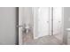 Well-lit bathroom featuring neutral tile flooring, toilet, and doors leading to various areas at 15 White Spruce Ct, Durham, NC 27703