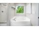 Bathroom features a soaking tub with a window view of the lush, green scenery at 15 White Spruce Ct, Durham, NC 27703