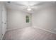 Bright bedroom featuring a ceiling fan, neutral walls, and window with tree view at 15 White Spruce Ct, Durham, NC 27703