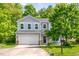 Charming two-story home featuring a two-car garage and a cozy front porch with inviting rocking chairs at 15 White Spruce Ct, Durham, NC 27703