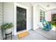 Inviting front porch with blue rocking chairs, a 'hello' mat, and potted plants at 15 White Spruce Ct, Durham, NC 27703