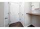 Hallway featuring three white doors, hardwood floors, a small desk, and access to multiple rooms at 15 White Spruce Ct, Durham, NC 27703