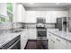 Well-lit kitchen with white cabinetry, stainless steel appliances, and granite countertops at 15 White Spruce Ct, Durham, NC 27703