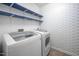 Modern laundry room featuring a side-by-side washer and dryer, and geometric wallpaper at 15 White Spruce Ct, Durham, NC 27703