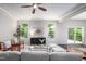 Bright living room featuring a ceiling fan, and access to the outdoor deck with forest views at 15 White Spruce Ct, Durham, NC 27703