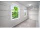 Spacious walk-in closet featuring wire shelving, neutral walls, and window view of the lush, green scenery at 15 White Spruce Ct, Durham, NC 27703