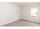 Neutral bedroom with carpet, white trim, and a view of backyard through window at 16 Decatur Dr, Fuquay Varina, NC 27526