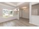 Bright dining area with modern chandelier, large window, and stylish floors at 16 Decatur Dr, Fuquay Varina, NC 27526