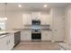 Well-lit kitchen with white cabinets, granite countertops, and stainless steel appliances at 16 Decatur Dr, Fuquay Varina, NC 27526