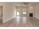 Large living room features grey wood floors, a modern fireplace, and a ceiling fan at 16 Decatur Dr, Fuquay Varina, NC 27526