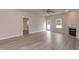 Spacious living room with fireplace, grey wood floors, ceiling fan and a bright window at 16 Decatur Dr, Fuquay Varina, NC 27526