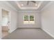 Large main bedroom with tray ceilings, carpet, a bright window, and easy access to the main bathroom at 16 Decatur Dr, Fuquay Varina, NC 27526