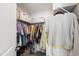 Walk-in closet with metal shelves and hanging rods, filled with colorful clothing at 1820 Grassy Falls Ln, Wendell, NC 27591