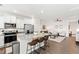 Bright kitchen with white cabinets, stainless steel appliances, granite island with bar seating, and hardwood floors at 1820 Grassy Falls Ln, Wendell, NC 27591