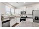 Modern kitchen with stainless steel dishwasher and microwave and white shaker cabinets, paired with neutral granite countertops at 1820 Grassy Falls Ln, Wendell, NC 27591