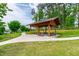 Wooden pavilion with benches surrounded by green grass, perfect for outdoor relaxation and community gatherings at 1820 Grassy Falls Ln, Wendell, NC 27591