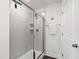 Tiled shower with frameless glass doors and modern fixtures enhances the updated bathroom at 1820 Grassy Falls Ln, Wendell, NC 27591