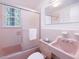 Vintage pink bathroom featuring a classic sink and shower with frosted glass sliding door at 203 Wood Cir, Chapel Hill, NC 27514