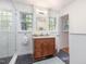 Stylish bathroom features slate floors, a glass shower, updated vanity, and natural light from two windows at 203 Wood Cir, Chapel Hill, NC 27514