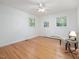 Bright bedroom showcases hardwood floors, neutral walls, ceiling fan, and a seating area by the window at 203 Wood Cir, Chapel Hill, NC 27514