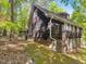 Side view of a two-story home with dark wood siding, surrounded by trees and a mossy lawn at 203 Wood Cir, Chapel Hill, NC 27514