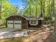 Side view of a two-car garage home exterior featuring mature trees and wood-shake siding at 203 Wood Cir, Chapel Hill, NC 27514