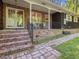 Inviting brick porch with classic rocking chairs and decorative railing, offering a relaxing outdoor space at 203 Wood Cir, Chapel Hill, NC 27514