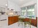 Eat-in kitchen features white cabinets, stainless oven, wood-paneled accent, and views to the trees at 203 Wood Cir, Chapel Hill, NC 27514