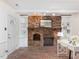 Living room featuring a brick fireplace, built-in shelves, and a brick floor at 203 Wood Cir, Chapel Hill, NC 27514
