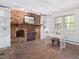 Living room featuring a brick fireplace, built-in shelves, and a brick floor at 203 Wood Cir, Chapel Hill, NC 27514