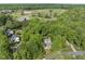 Aerial view of a residential home with mature trees and manicured landscaping with a baseball field and green space in the background at 204 Black Forest Dr, Clayton, NC 27527