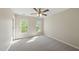 Bright bedroom featuring neutral walls, plush carpet, ceiling fan, and natural light through large windows at 204 Black Forest Dr, Clayton, NC 27527