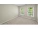 Bedroom featuring neutral walls, plush carpet, and natural light through two large windows at 204 Black Forest Dr, Clayton, NC 27527