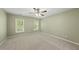 Bedroom features neutral carpet, two windows providing natural light, and a ceiling fan at 204 Black Forest Dr, Clayton, NC 27527