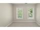 Bedroom featuring neutral walls, plush carpet, and natural light through two large windows at 204 Black Forest Dr, Clayton, NC 27527