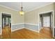 Spacious dining room with hardwood floors, elegant lighting, and access to other rooms at 204 Black Forest Dr, Clayton, NC 27527