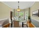 Elegant dining room featuring a glass table, white chairs, and bay window at 204 Black Forest Dr, Clayton, NC 27527