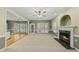 Bright living room boasts a fireplace, neutral carpet, ceiling fan, and ample natural light from the large windows at 204 Black Forest Dr, Clayton, NC 27527