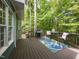 Back deck featuring a grill, table, chairs, and view of the wooded yard at 204 Flint Point Ln, Holly Springs, NC 27540