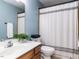 Bathroom featuring a single sink, mirror, toilet, and a shower with a curtain at 204 Flint Point Ln, Holly Springs, NC 27540