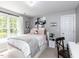 A bedroom with a large window, white bed, and a cozy, inviting atmosphere at 204 Flint Point Ln, Holly Springs, NC 27540