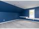 Bedroom with blue walls, neutral carpet, and built-in shelving near a window at 204 Flint Point Ln, Holly Springs, NC 27540