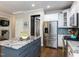 Well-appointed kitchen with granite countertops, stainless steel refrigerator, and a view into a separate sitting area at 204 Flint Point Ln, Holly Springs, NC 27540