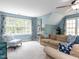 Spacious living room featuring large windows and cozy seating area at 204 Flint Point Ln, Holly Springs, NC 27540